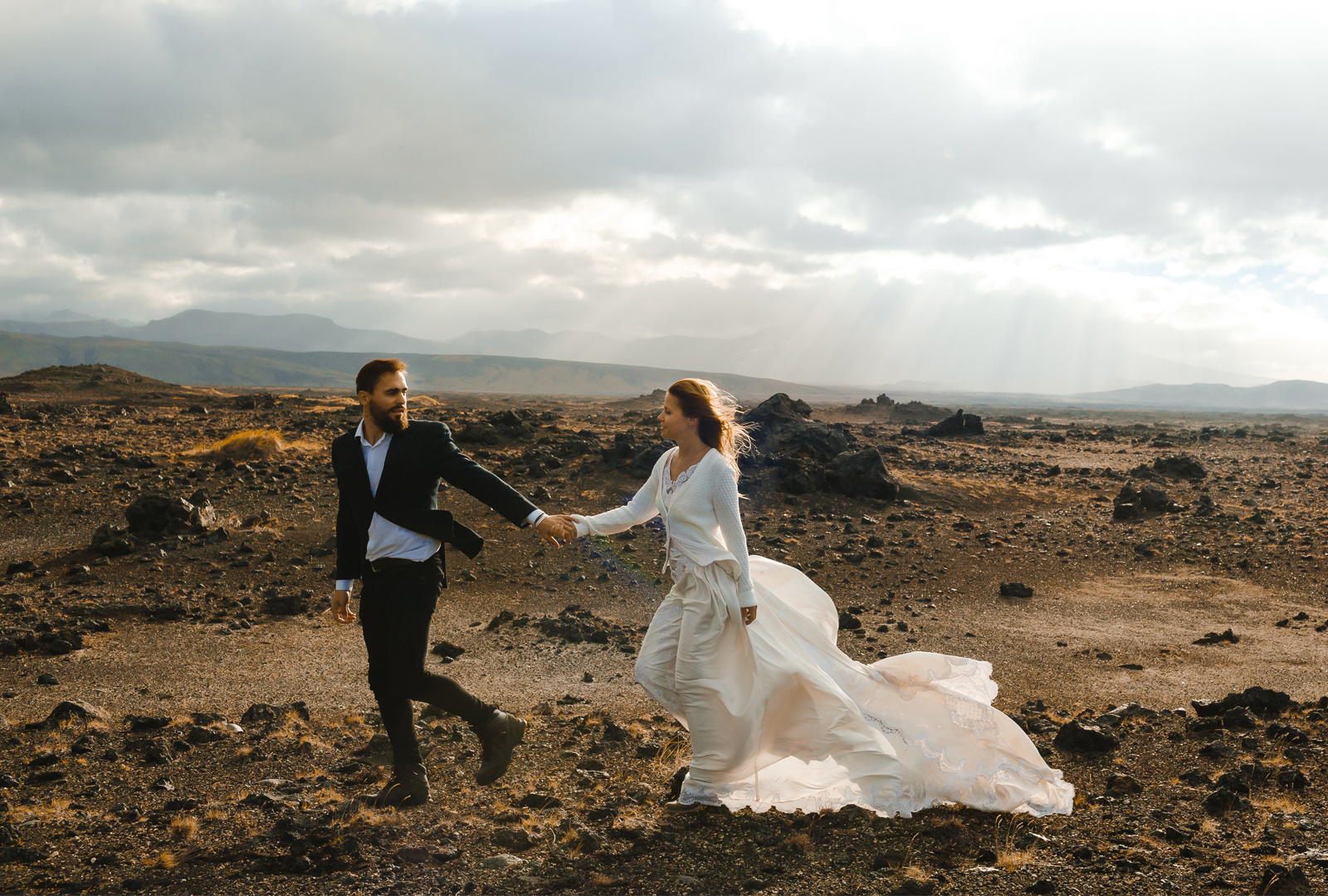 Couple walking through black lava landscape in Iceland